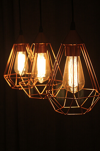 Filament bulbs used in geometric pendant light fittings.